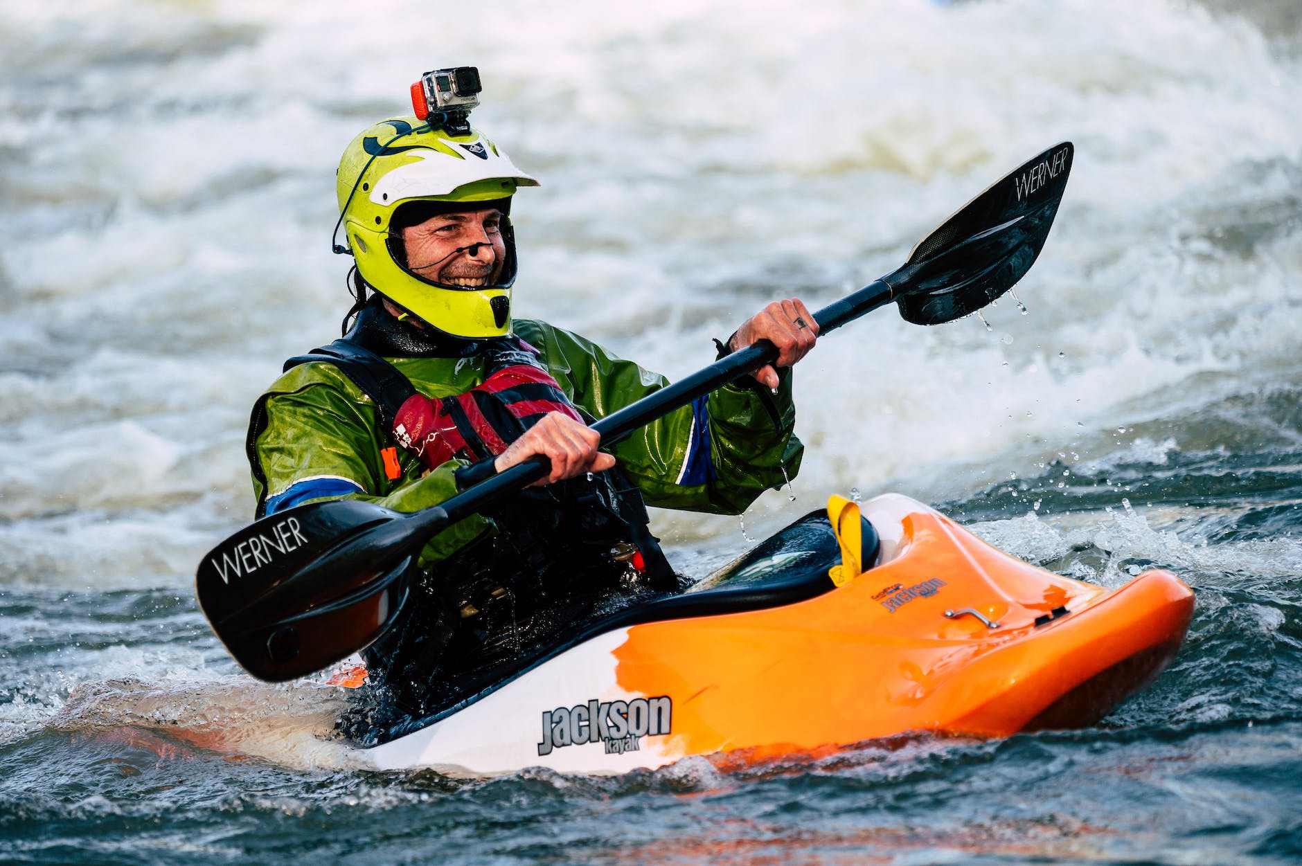 photo of smiling man whitewater kayaking